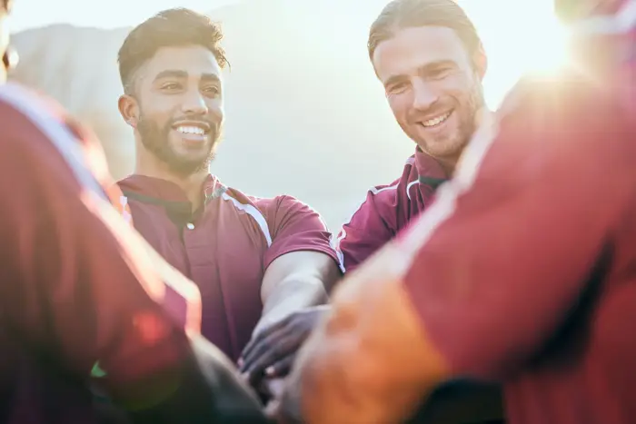 Een team legt de handen op elkaar als teken van samenwerking